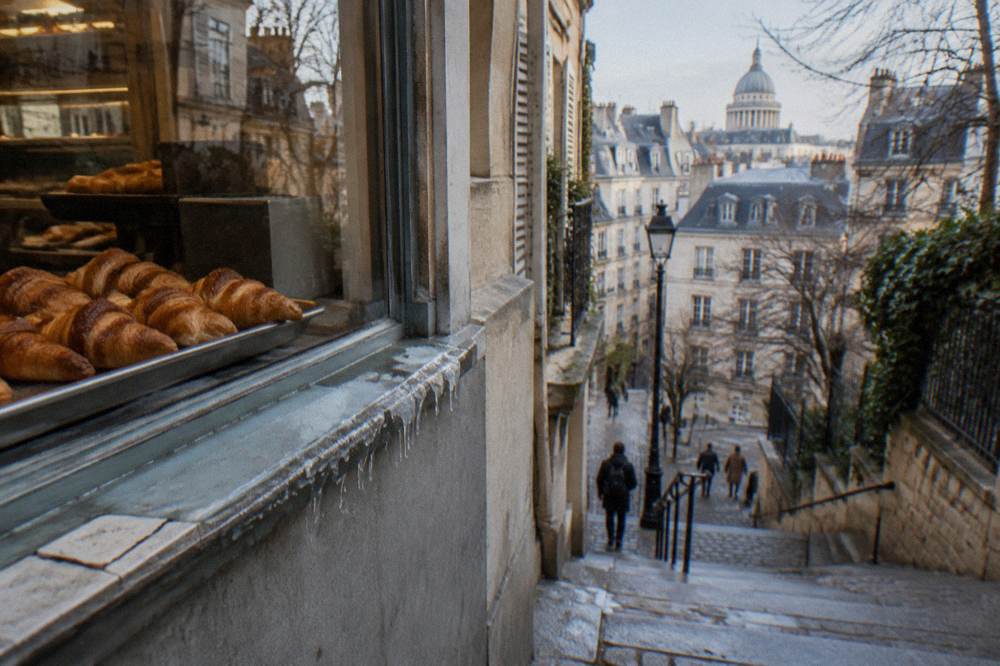 Freshly baked golden croissants arranged on a tray in a Paris bakery window