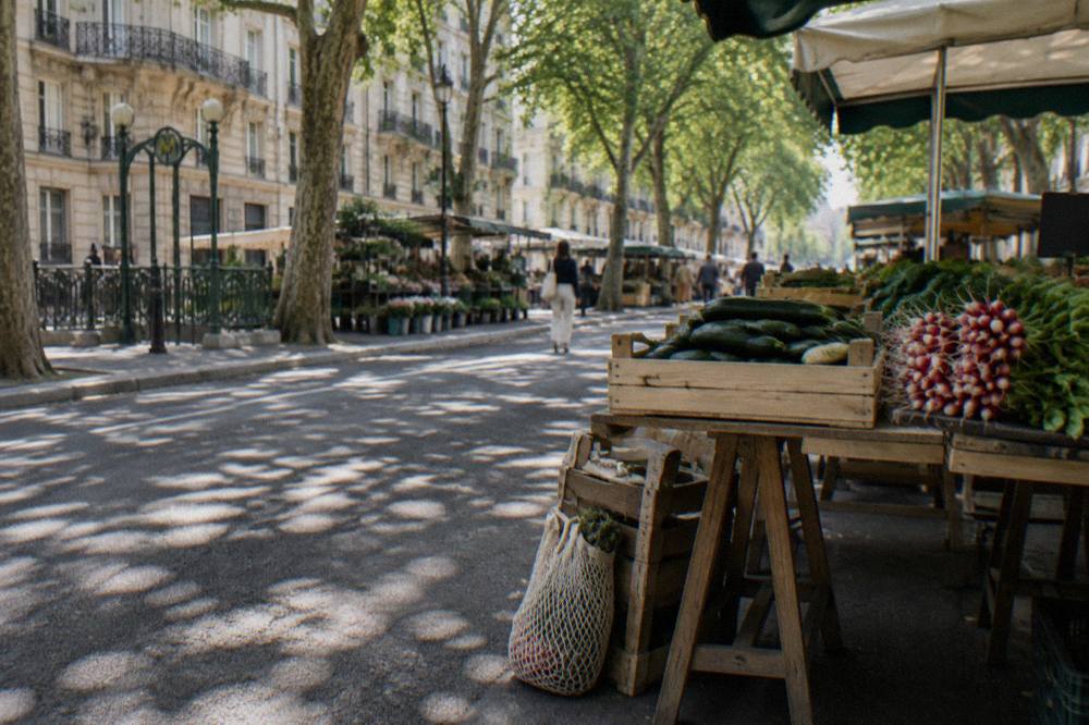 An outdoor Paris food market stall with crates of seasonal vegetables in the morning