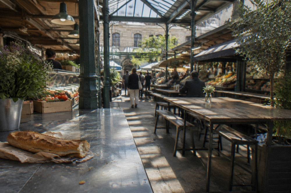 A covered market hall with food stalls and shared tables