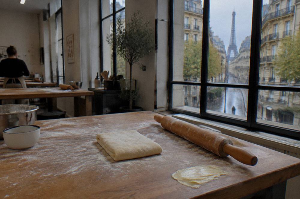 Rolling pin and dough on a floured wooden workbench in a kitchen classroom