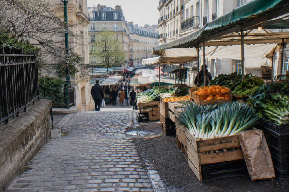 Open-air Paris market stalls with crates of fresh produce in the morning