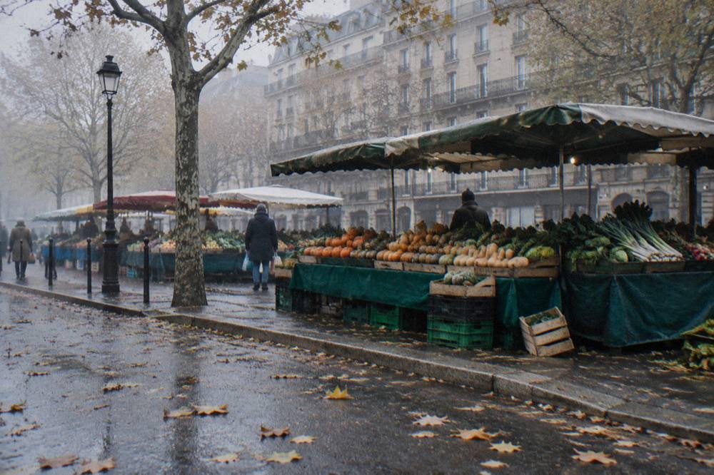Colourful produce stalls lined up at an outdoor Paris market in the morning