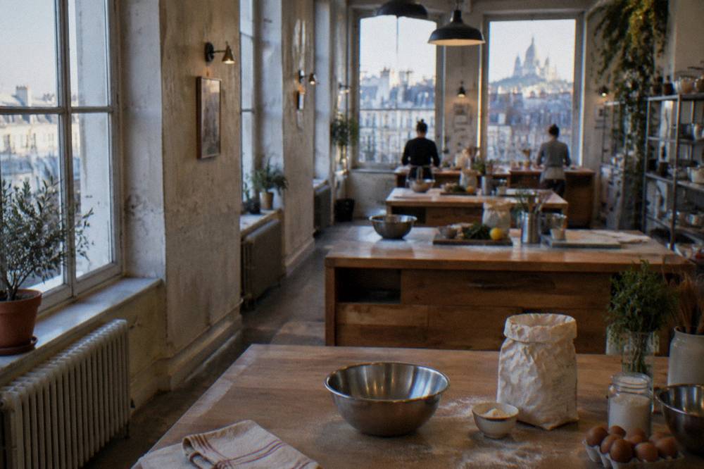 Small group of workstations with mixing bowls and ingredients laid out in a bright kitchen