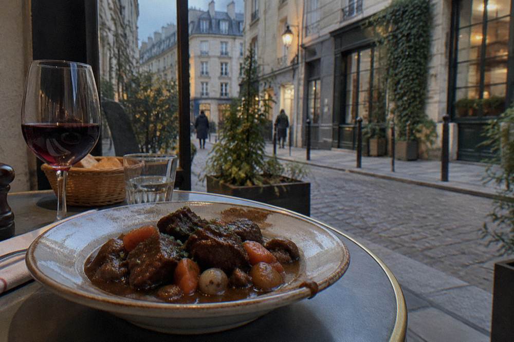 A rustic plate of braised beef stew with root vegetables on a bistro table
