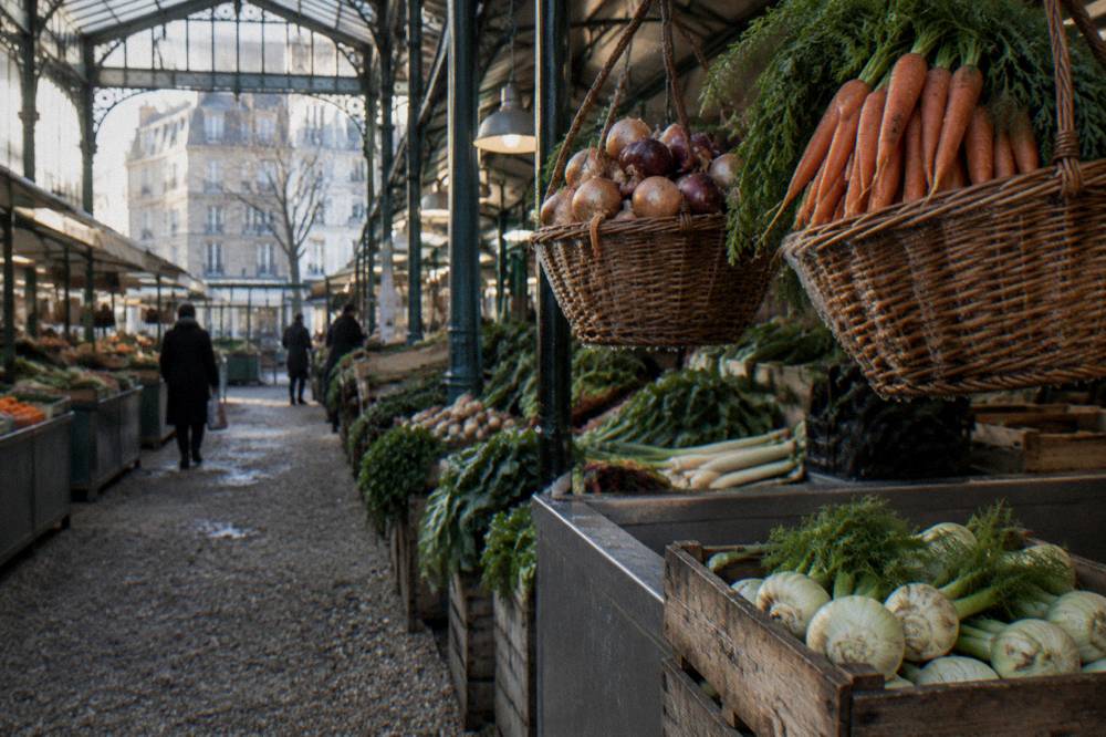 A covered market hall with produce stalls and hanging baskets of vegetables