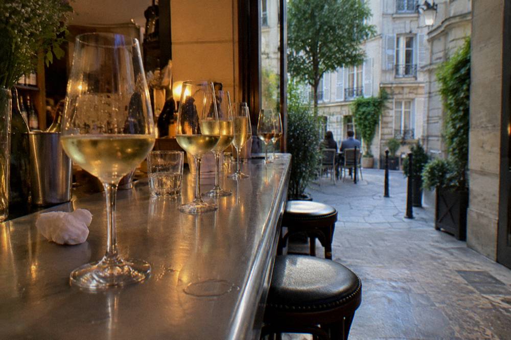 Tasting glasses of white wine and champagne in a row on a Paris counter